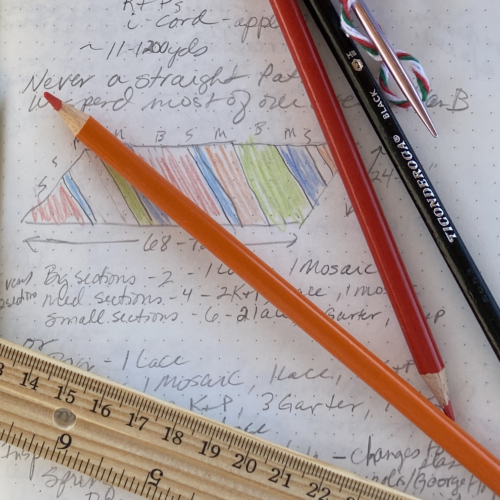 Close up of a notebook page with a rectangular shawl colored drawing, a ruler and colored pencils.